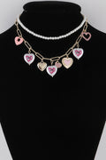 Heart charm necklace with faux pearl strand and pink, white, and purple heart pendants