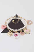 Gold-tone pearl bracelet with heart charms and pink, glitter, and enamel pendants