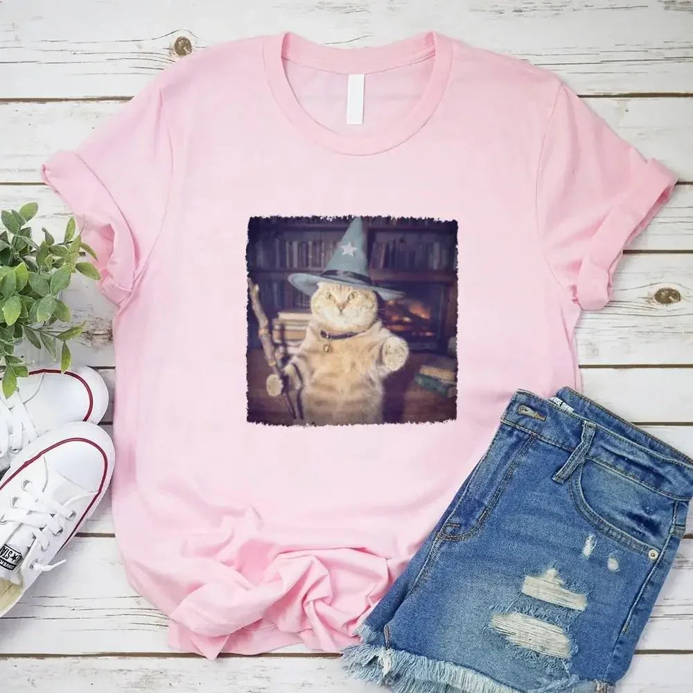 Pink crew-neck cat wizard graphic T-shirt with denim shorts, flat lay