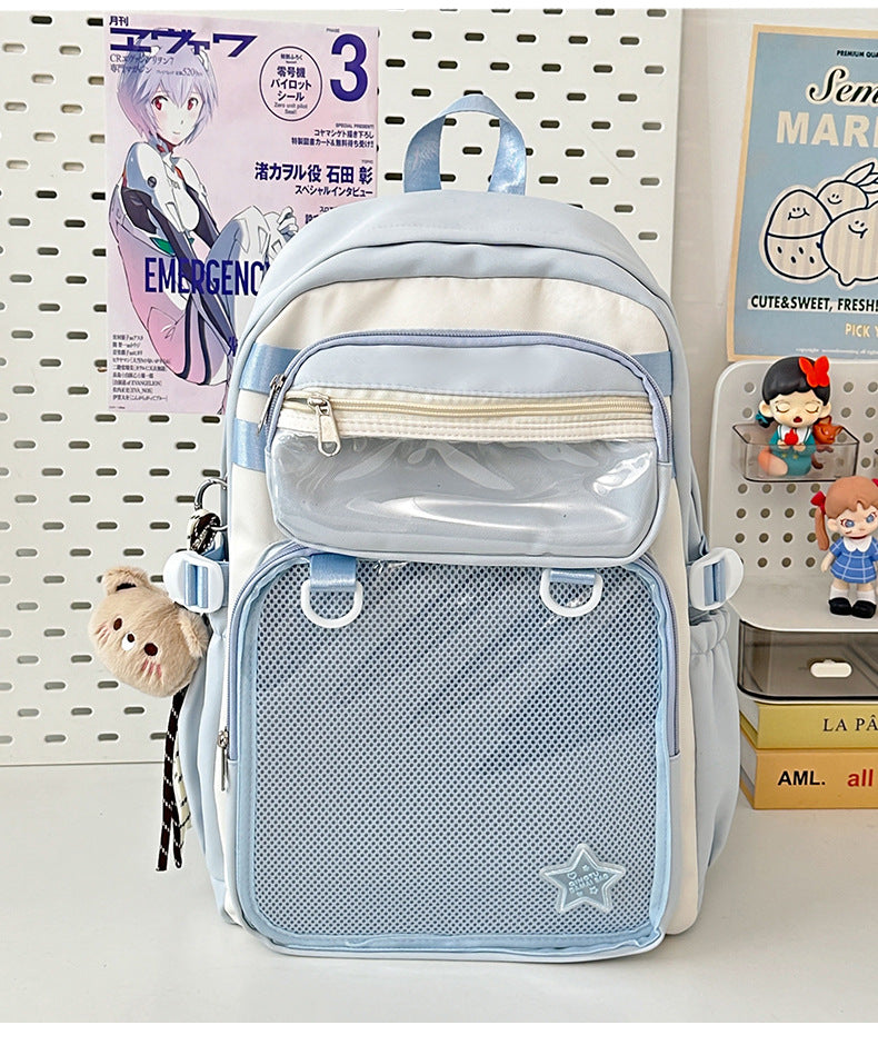 Light blue nylon backpack with front zip pocket, mesh panel, and star patch