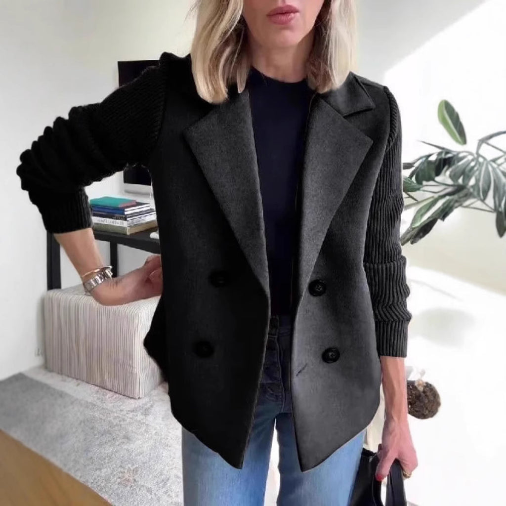 Black double-breasted lapel jacket with ribbed knit sleeves and four front buttons.