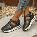 Black hollow wedge sneaker with three strap panels and cushioned sole
