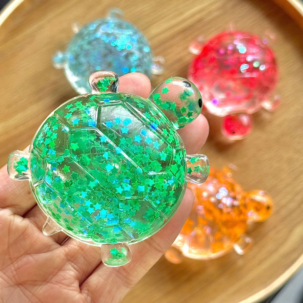 Green glitter bubble-bead sea star stress toy with translucent shell, starfish shape