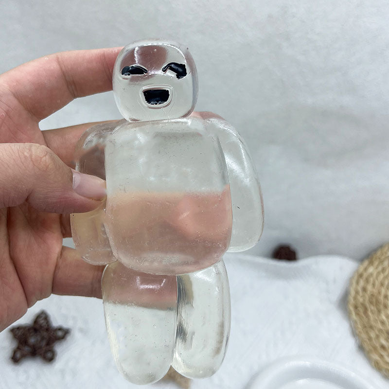 Clear transparent robot stress relief squeeze toy held in hand, round face with black details