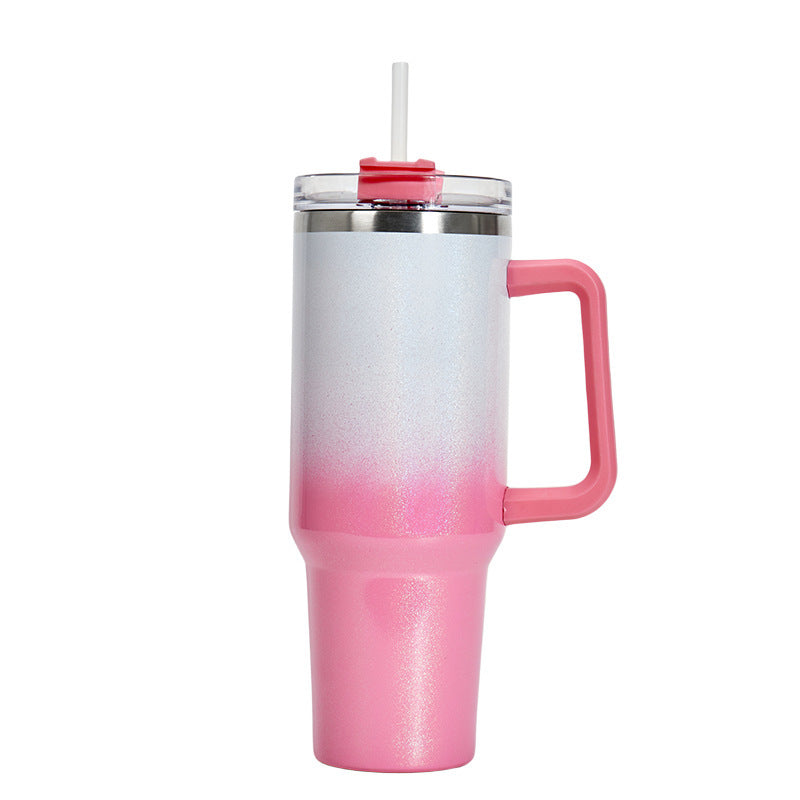 Insulated stainless steel tumbler with silver-to-pink gradient finish, handle, and clear lid
