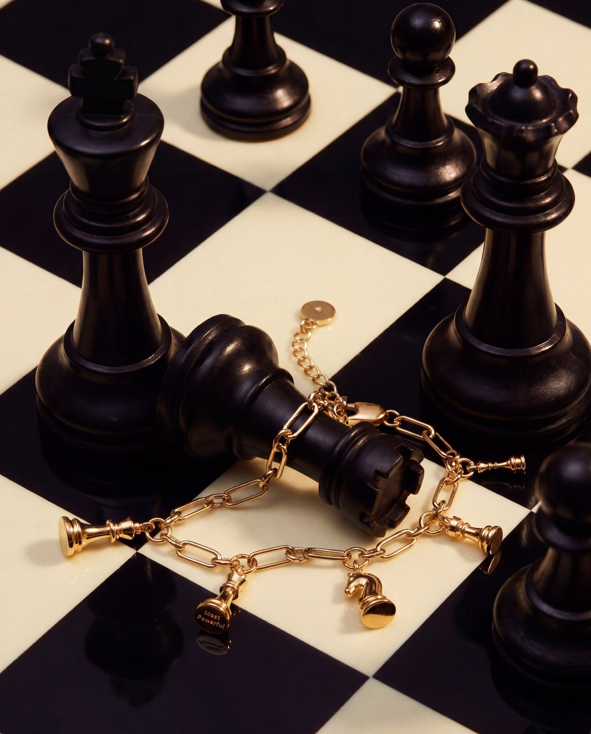 Gold chess charm bracelet with dangling chess-piece charms on chain