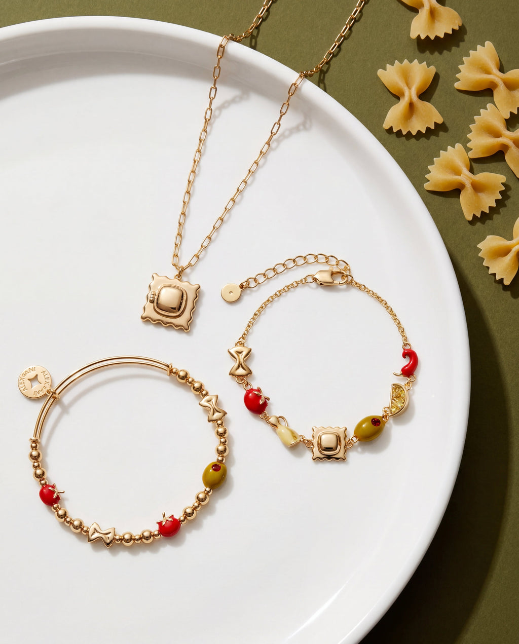 Gold-tone beaded bracelets with red and yellow beads and small square charm on plate