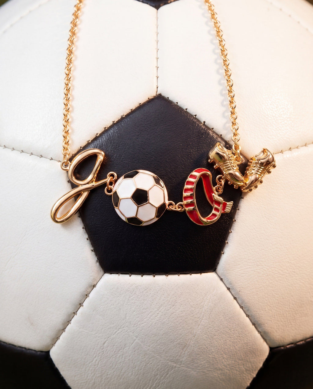 Gold soccer bracelet with soccer ball and goal post charms, plus red boot charm on chain