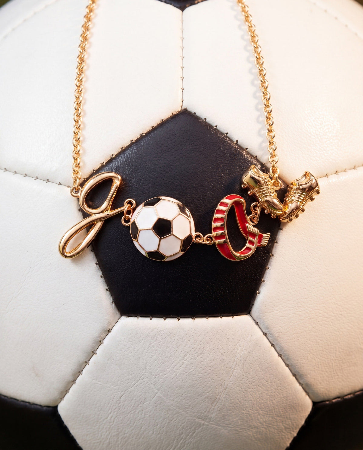 Gold soccer bracelet with soccer ball and goal post charms, plus red boot charm on chain