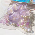 Purple glitter cat paw squeeze toy with pearl beads and butterfly charm in bag