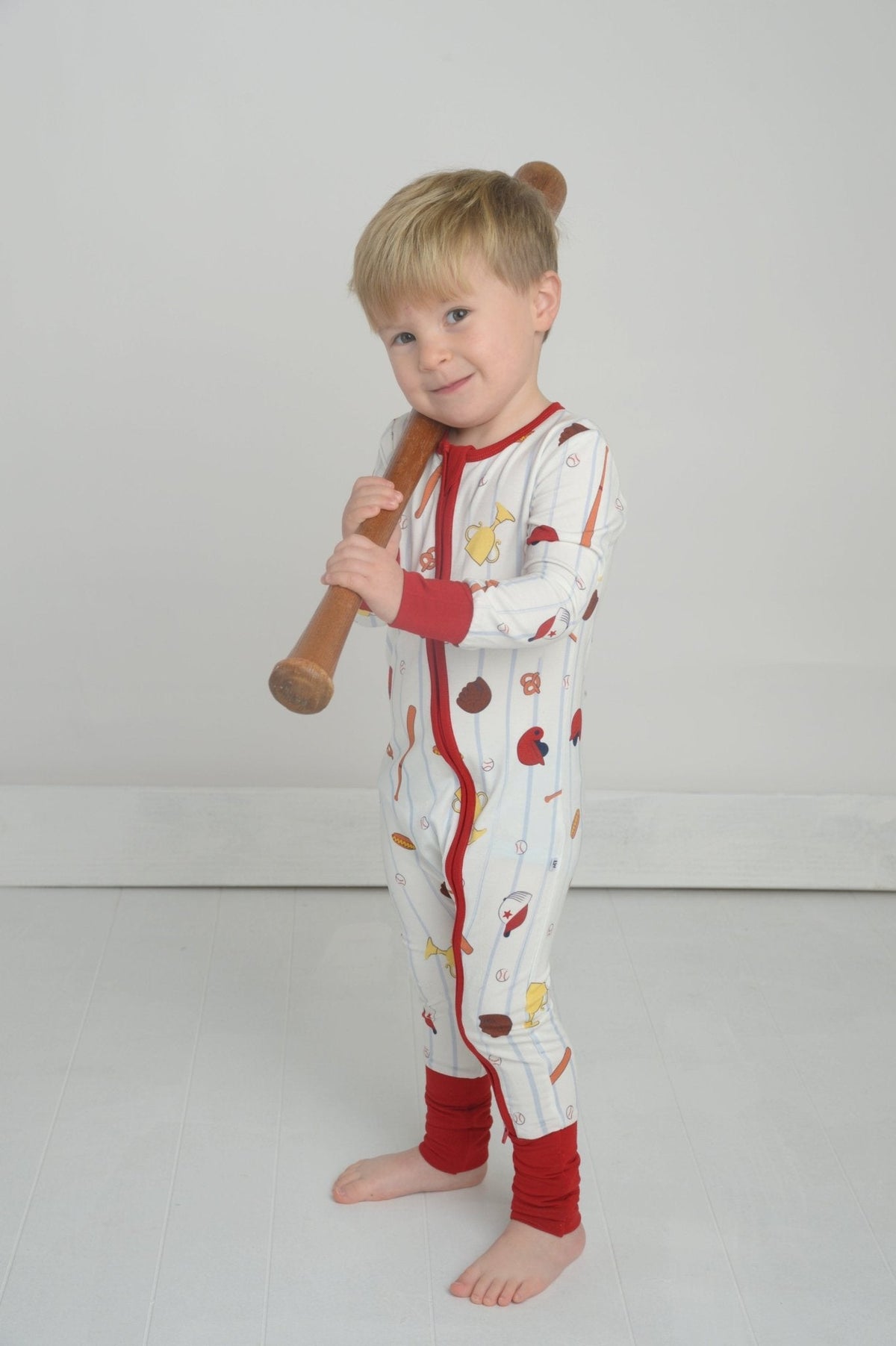Toddler baseball pajama romper with red-trim cuffs and zipper front, multicolor play print