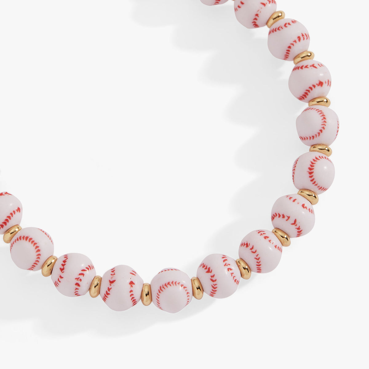 Baseball beaded bangle close-up with white ball beads, red laces, and gold spacers