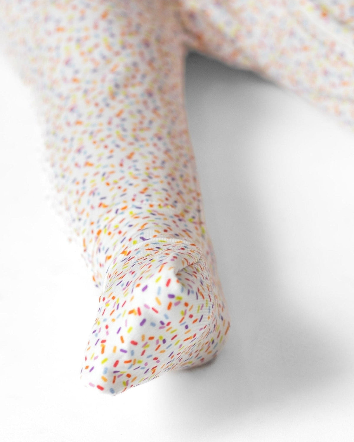 Sprinkle-print pajama romper foot cuff detail, multicolor confetti pattern