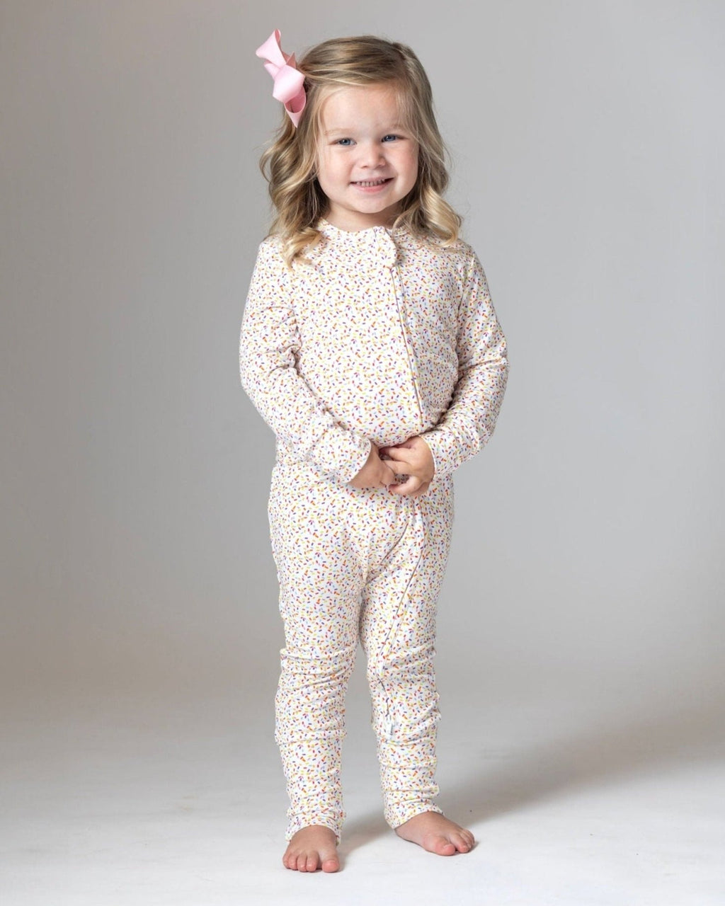 White sprinkle-print toddler pajama romper with long sleeves and pants legs