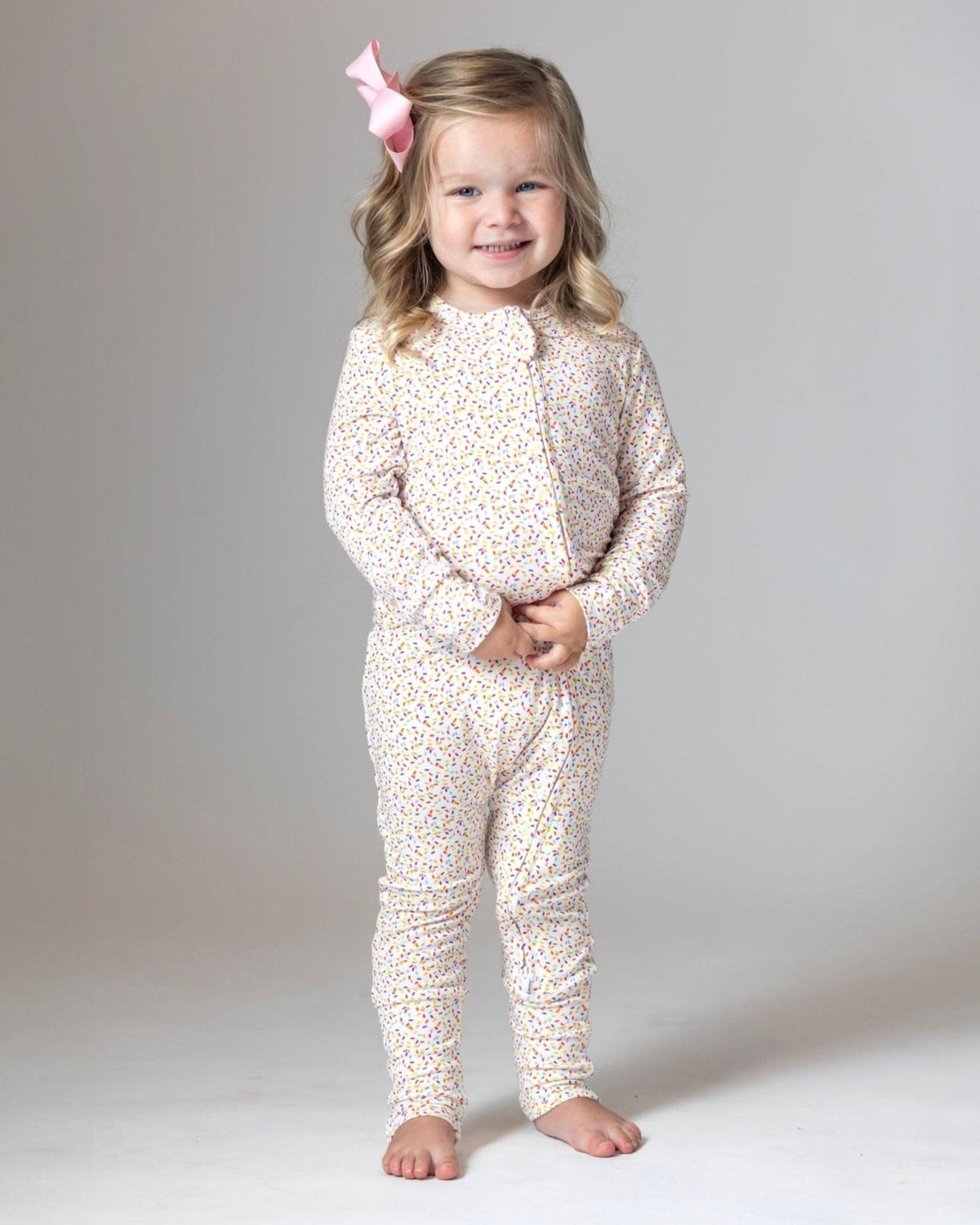 White sprinkle-print toddler pajama romper with long sleeves and pants legs
