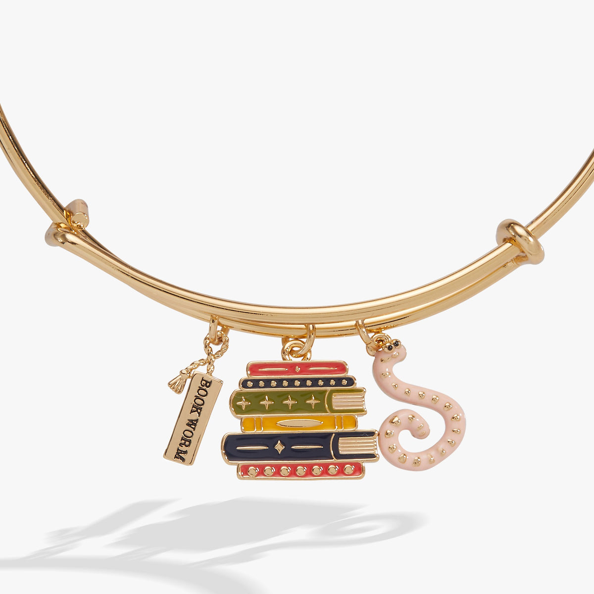 Gold bangle with stacked books charm and pink octopus-shaped charm, front view