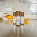 Set of three lip balm sticks in tan push-up tubes labeled Grapefruit Lemon