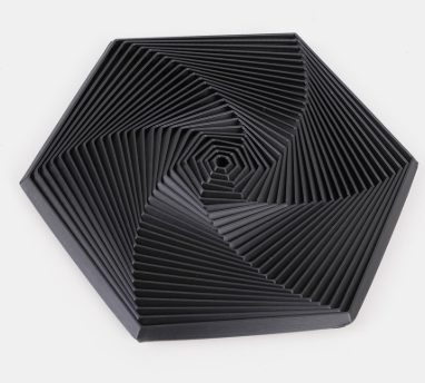 Hexagon sensory fidget toy with black spiral ridges and a small concentric center.