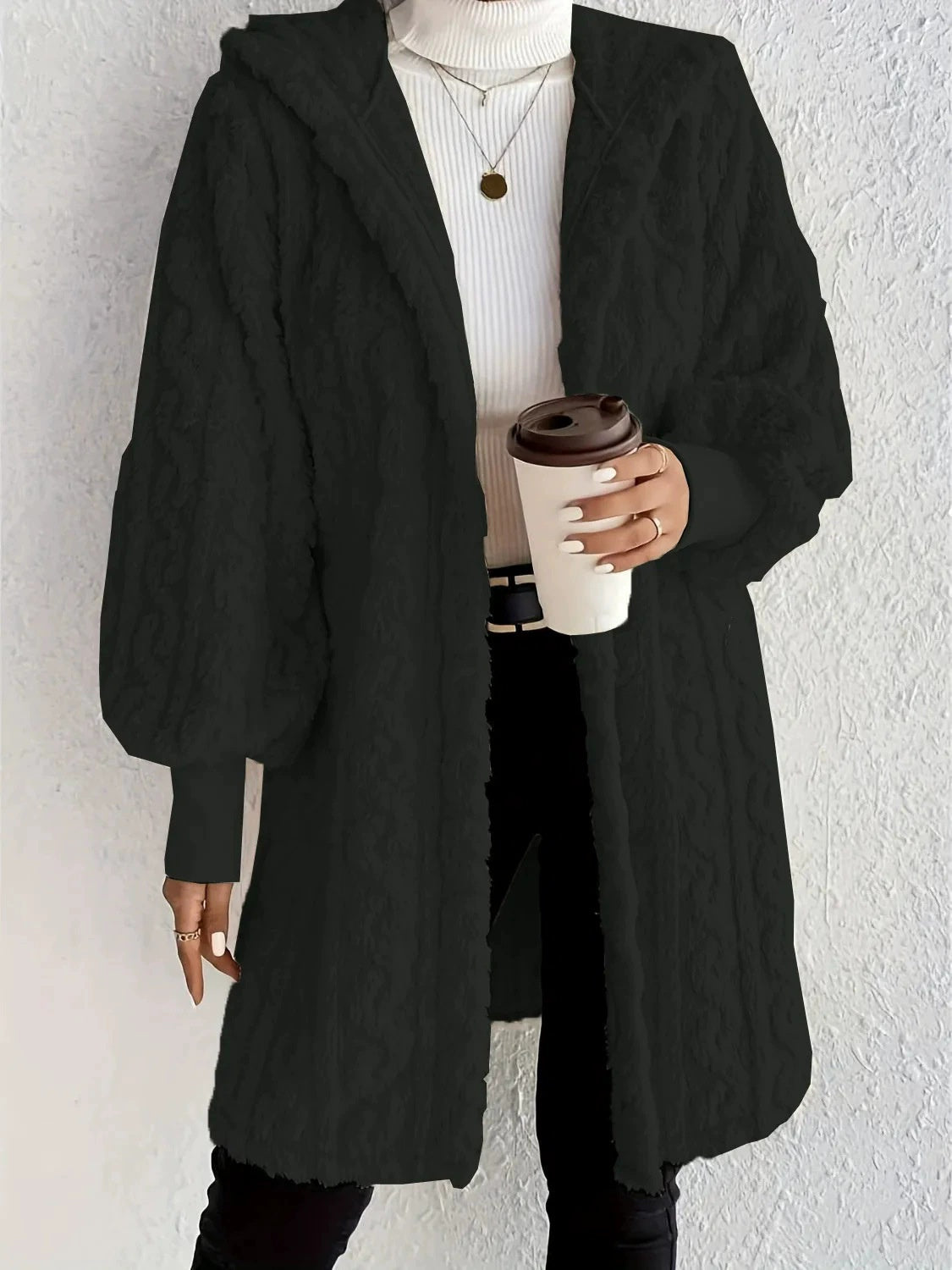 Hooded long plush coat in black, open front, textured fabric and wide sleeves.