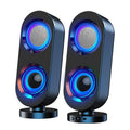 Pair of black desktop subwoofer speakers with blue-lit circular drivers, on round stands.
