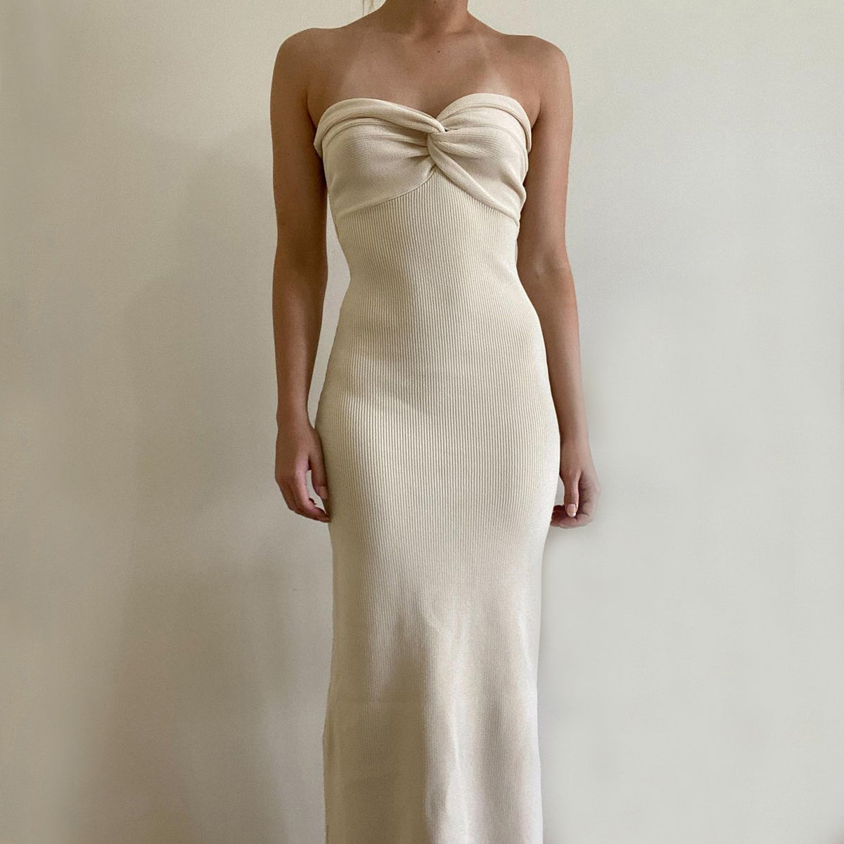 Cream off-shoulder knit long dress with knotted bust and streamlined fitted silhouette.
