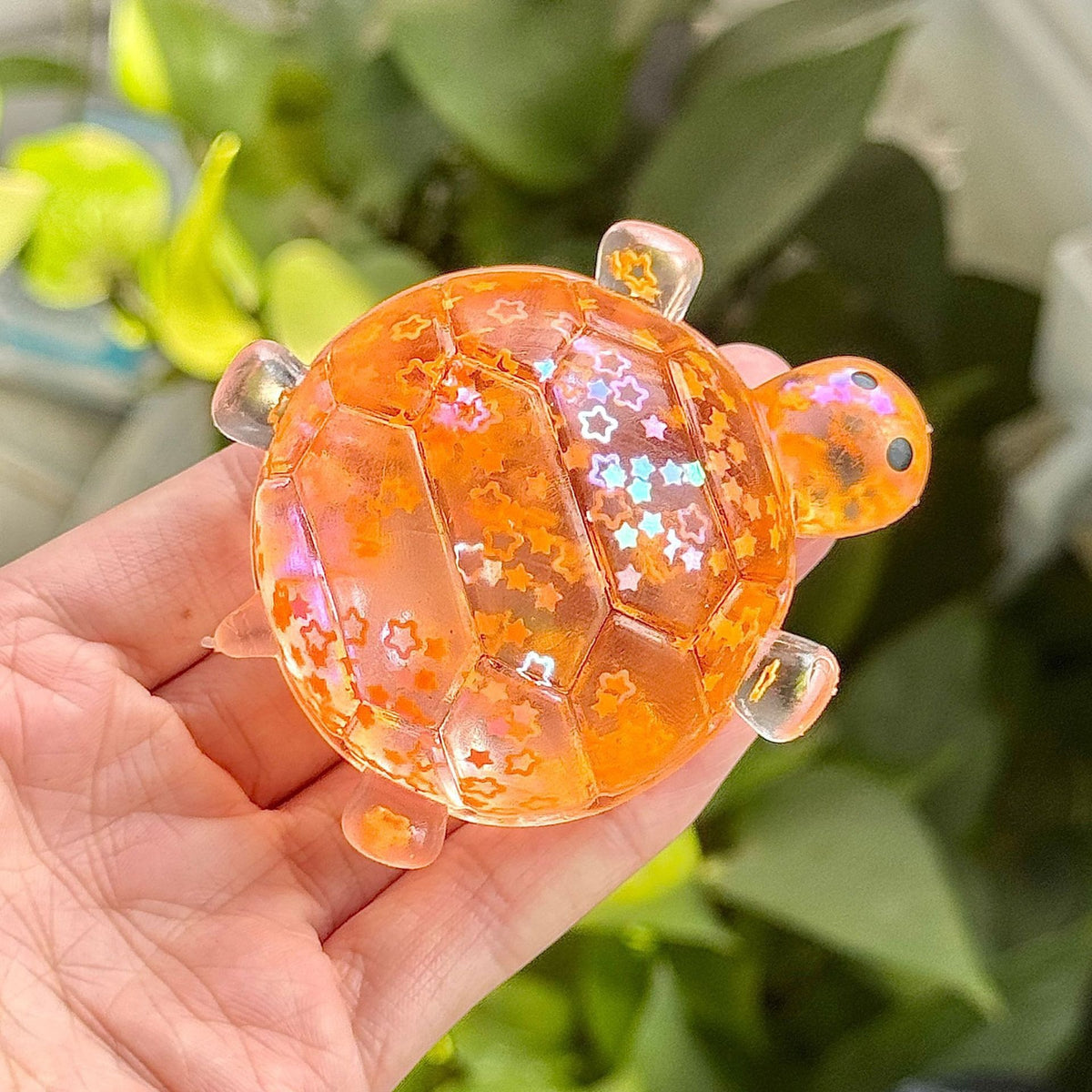 Orange glitter bubble-bead sea star stress toy, slow-rebound, held