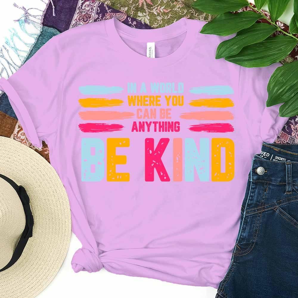 Lilac Be Kind graphic tee with colorful “BE KIND” print and stacked slogan text