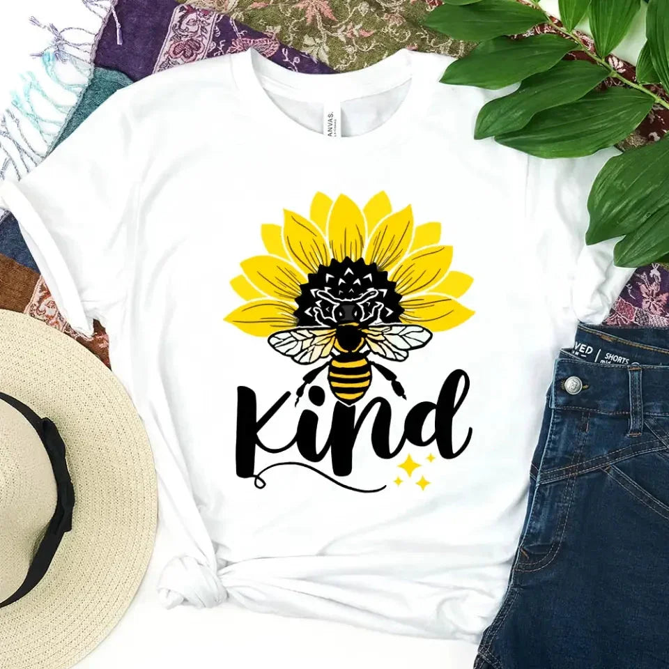 White T-shirt with sunflower, bee, and “kind” graphic on the front.