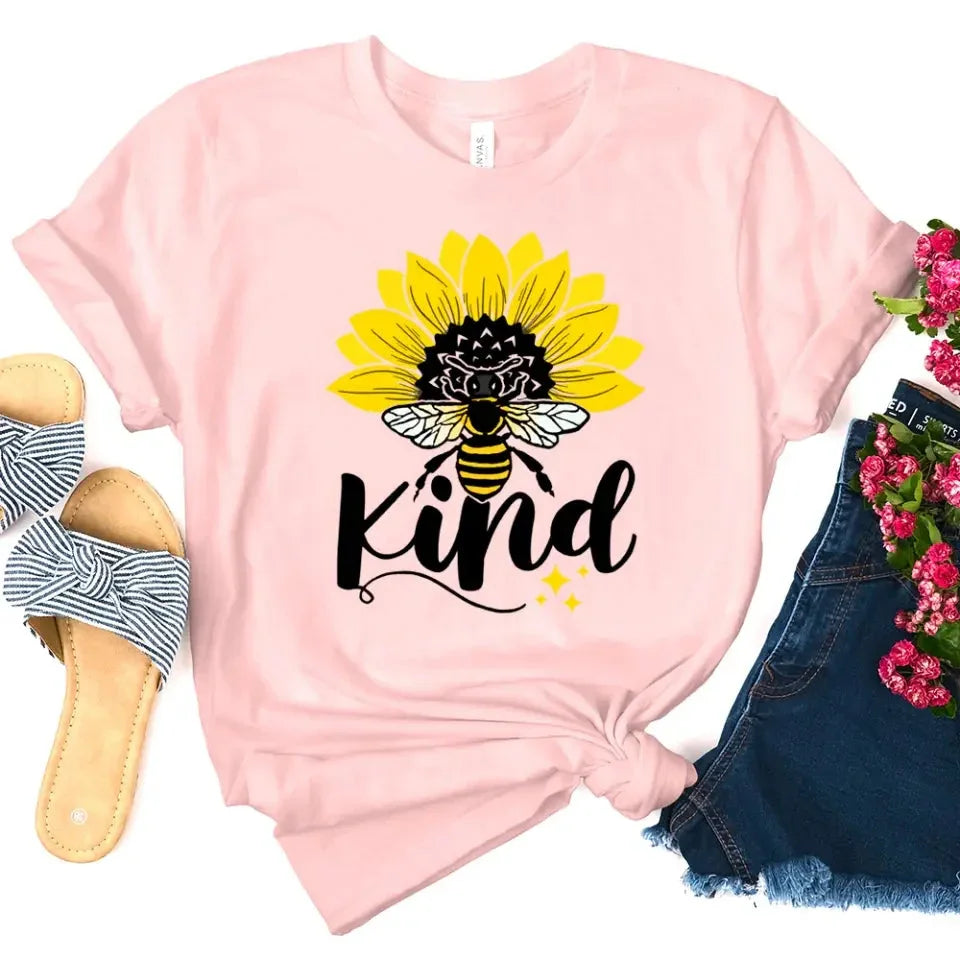 Pink T-shirt with sunflower, bee, and “kind” graphic on the front.