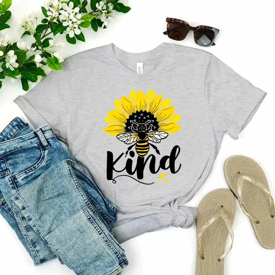 Grey T-shirt with sunflower, bee, and “kind” graphic on the front.