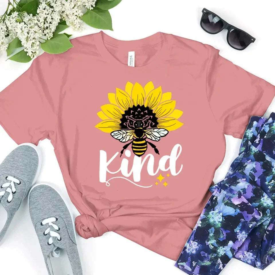 Mauve T-shirt with sunflower, bee, and “kind” graphic on the front.