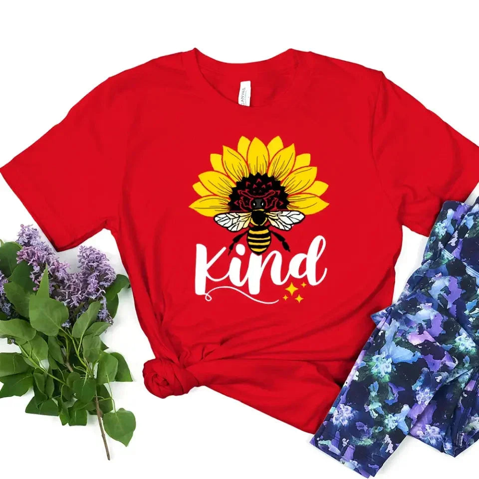 Red T-shirt with sunflower, bee, and “kind” graphic on the front.