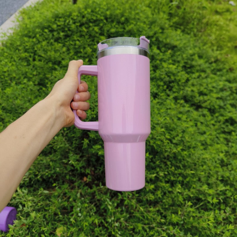 Large insulated stainless steel tumbler, light pink finish with clear lid, straw, and handle