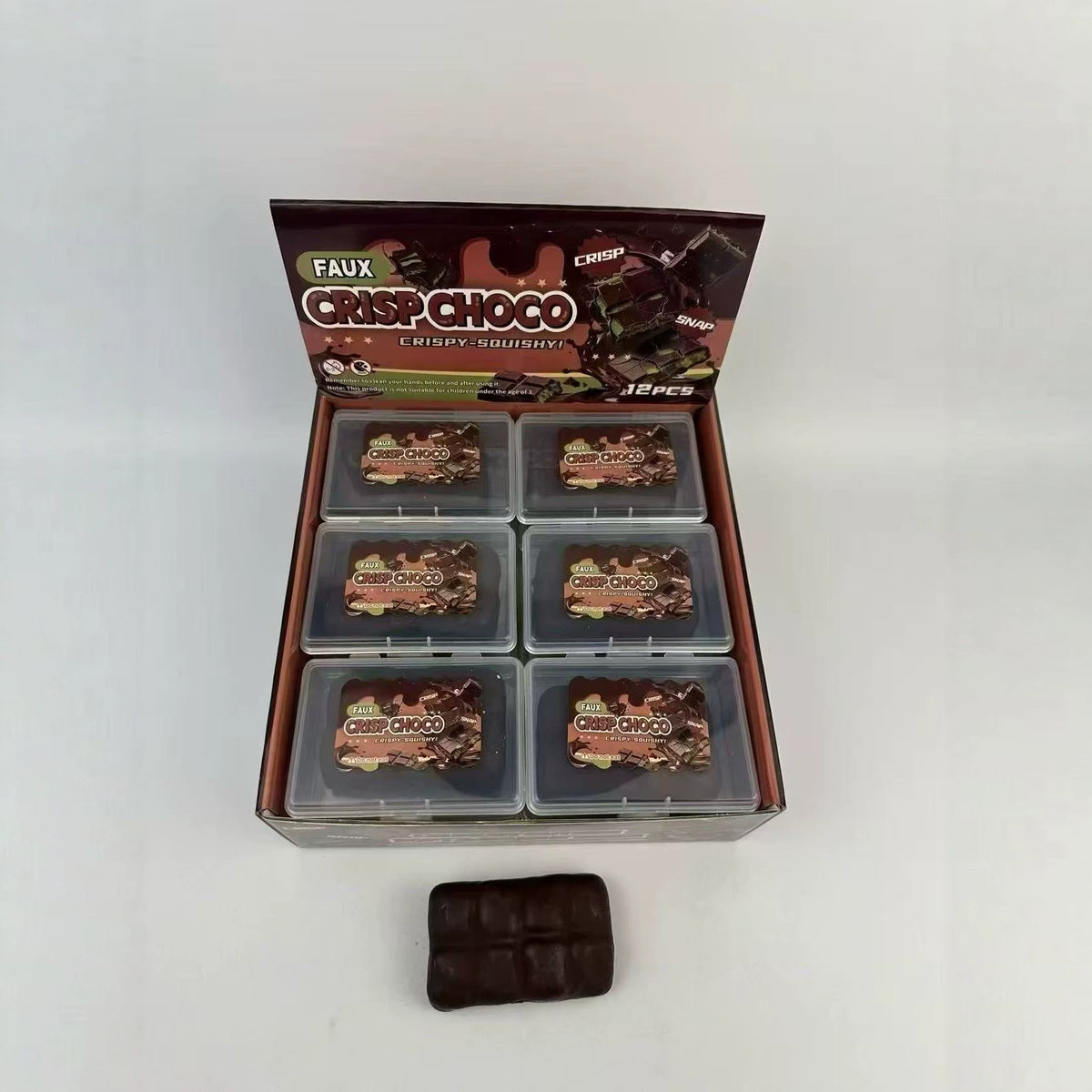 Dark brown rectangular squeeze toy shown with boxed set in gray tray compartments