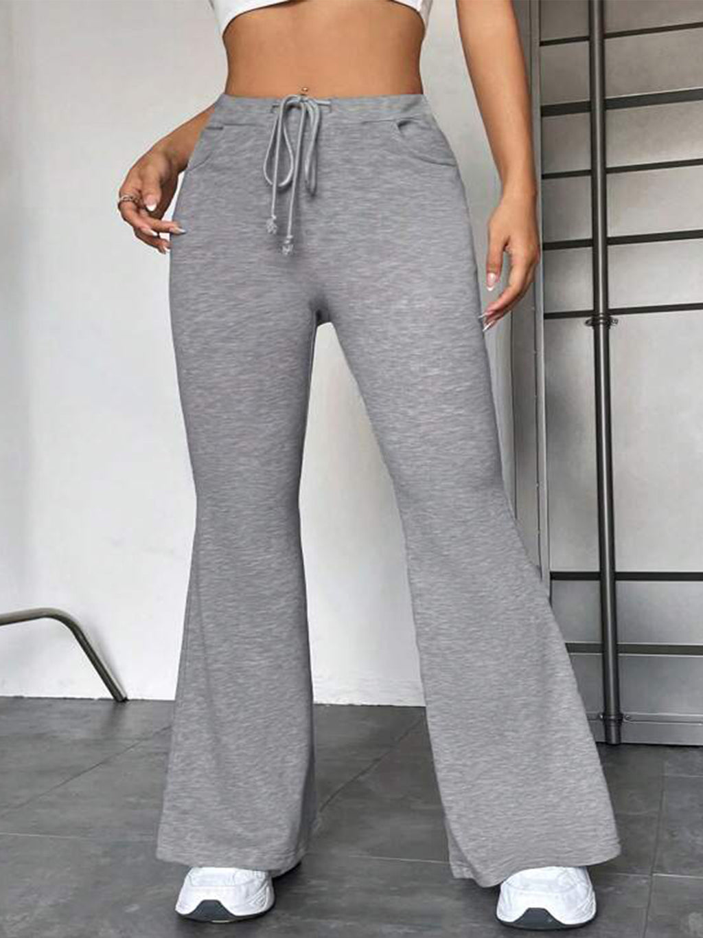 Gray flared yoga pants with drawstring waist and wide bell bottom.