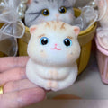 Cream cat silicone squeeze toy plush with big blue eyes, pink nose, and smile