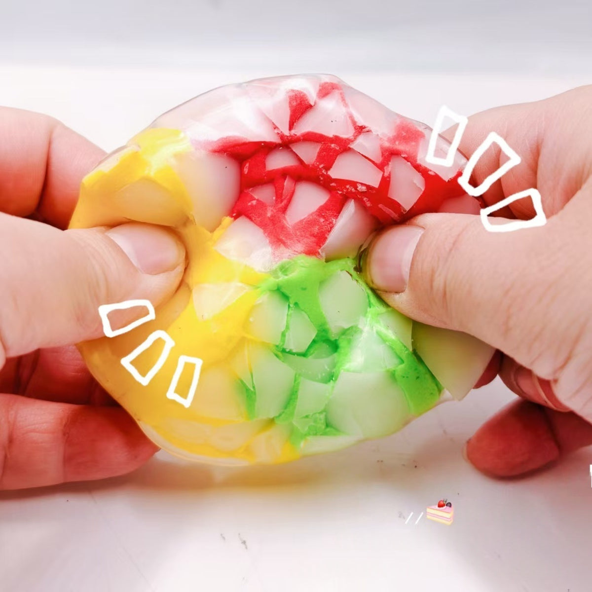 Multicolor crispy sphere stress-relief squeeze toy with crackle pattern, held