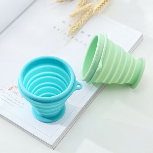 Collapsible silicone travel coffee cup in teal with gray lid and folded sides
