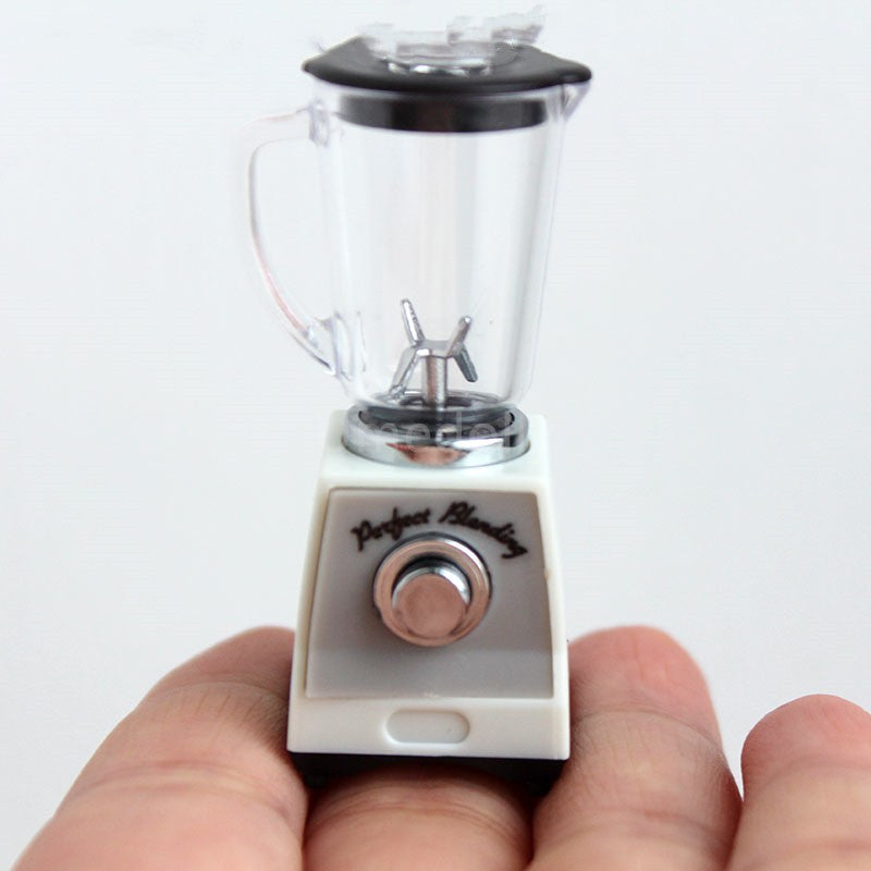 Ivory toy blender close-up held in hand; clear jar, black lid, and front dial