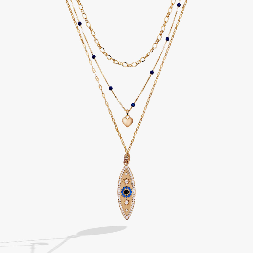Gold evil eye pendant necklace with layered chains and blue bead accents