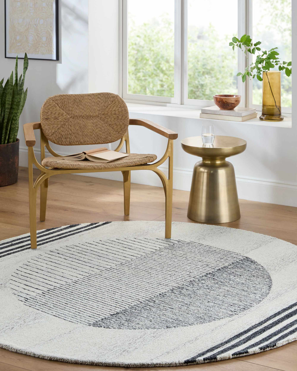 Round rug with geometric pattern in a room with a chair, side table, and window.
