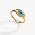 Gold evil eye healing stone ring with blue center stone and crystal bead halo