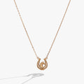 Gold horseshoe pendant necklace with star details on a fine chain