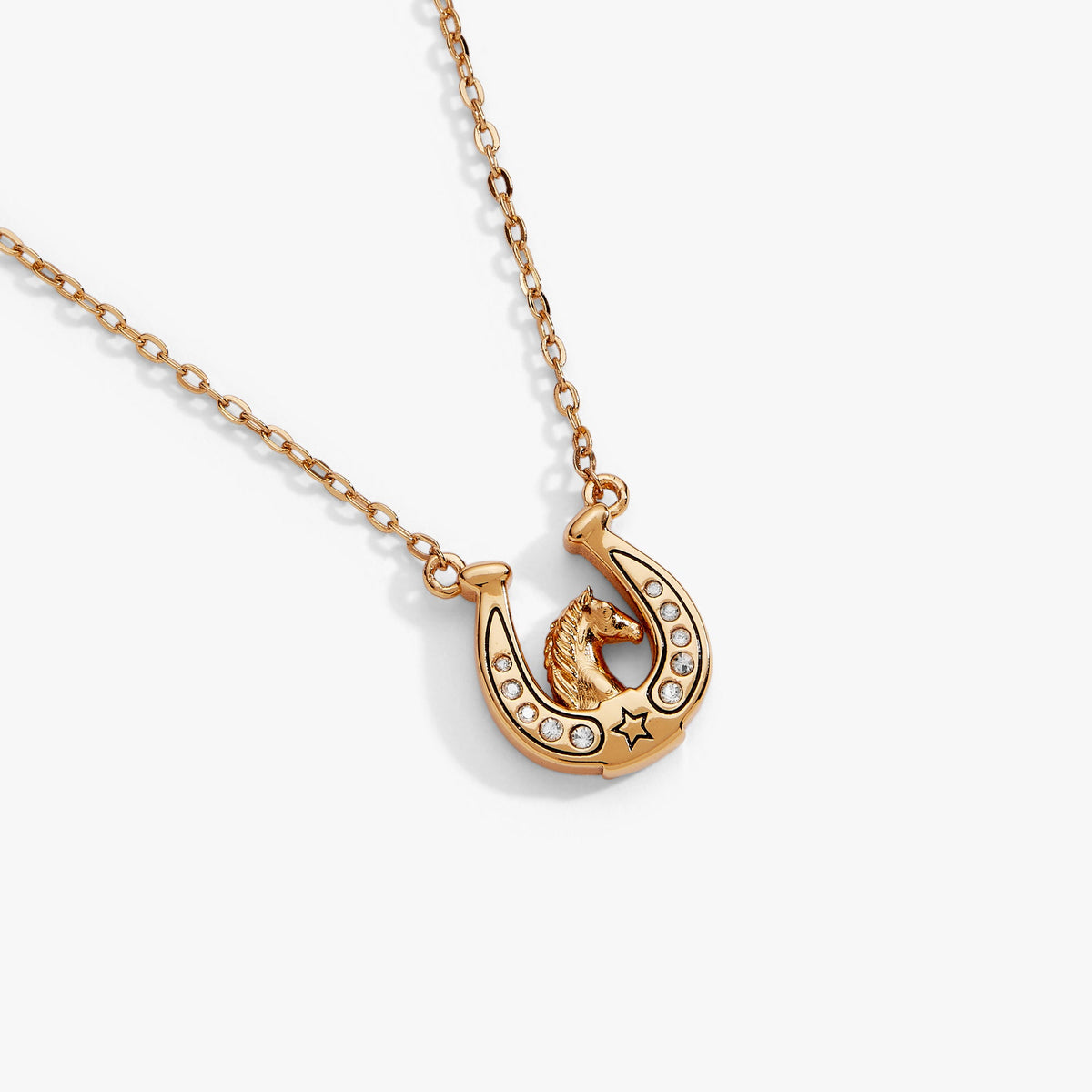Gold horseshoe pendant necklace with horse-head and star cutouts, on chain