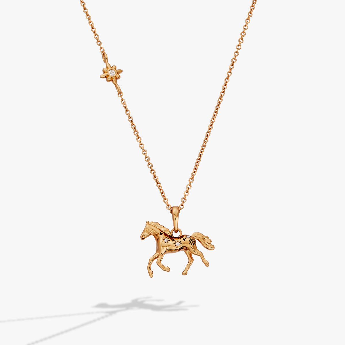 Gold horse pendant necklace with small flower charm and horse figure on chain
