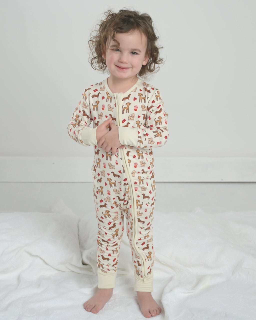Toddler dog-print pajama romper with front zipper and footed cuffs, cream fabric