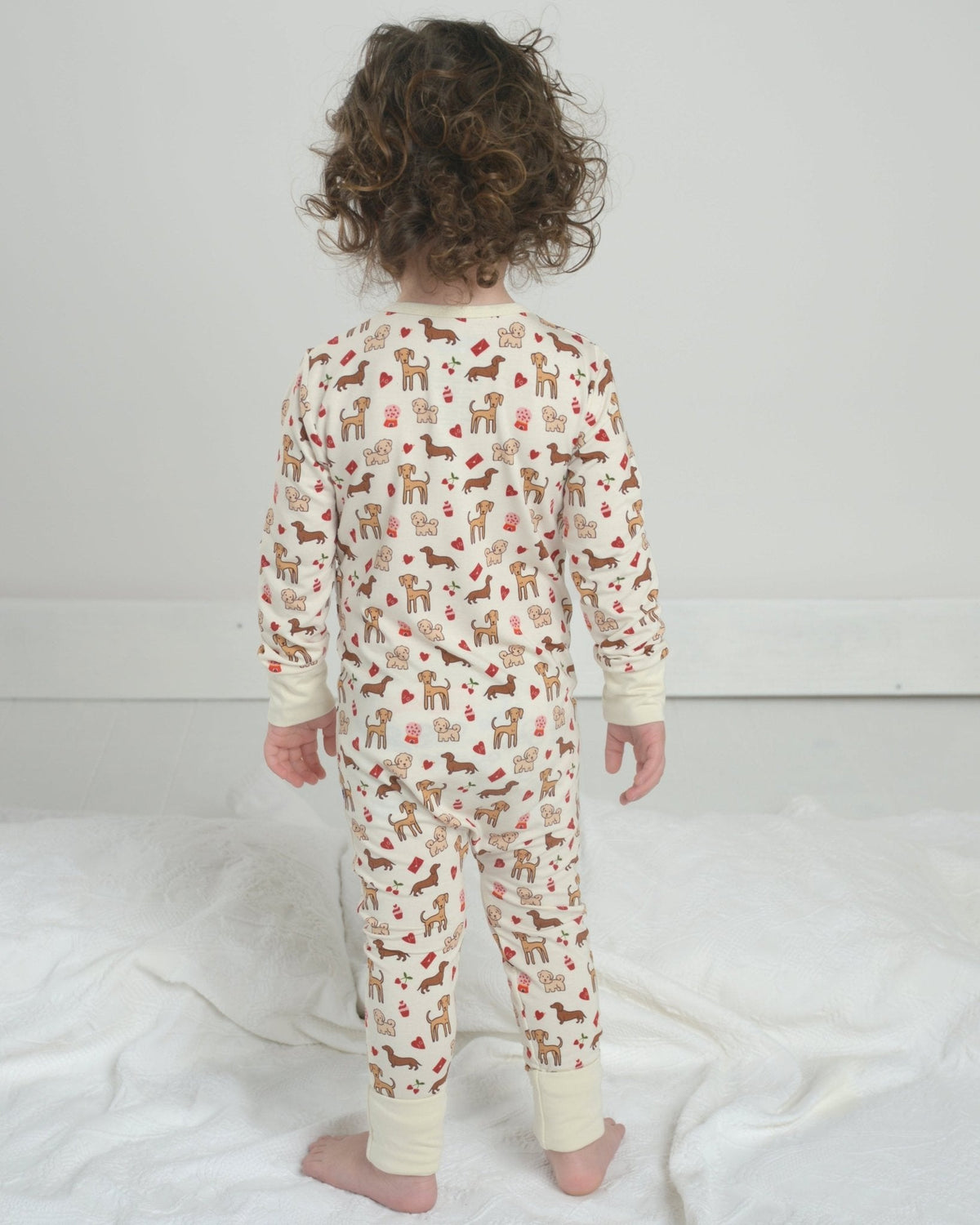 Toddler dog-print pajama romper, rear view, front zipper and long sleeves, cream fabric