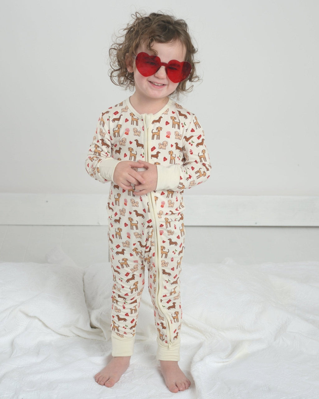 Toddler dog-print bamboo pajama romper with front zipper and long sleeves, cream base