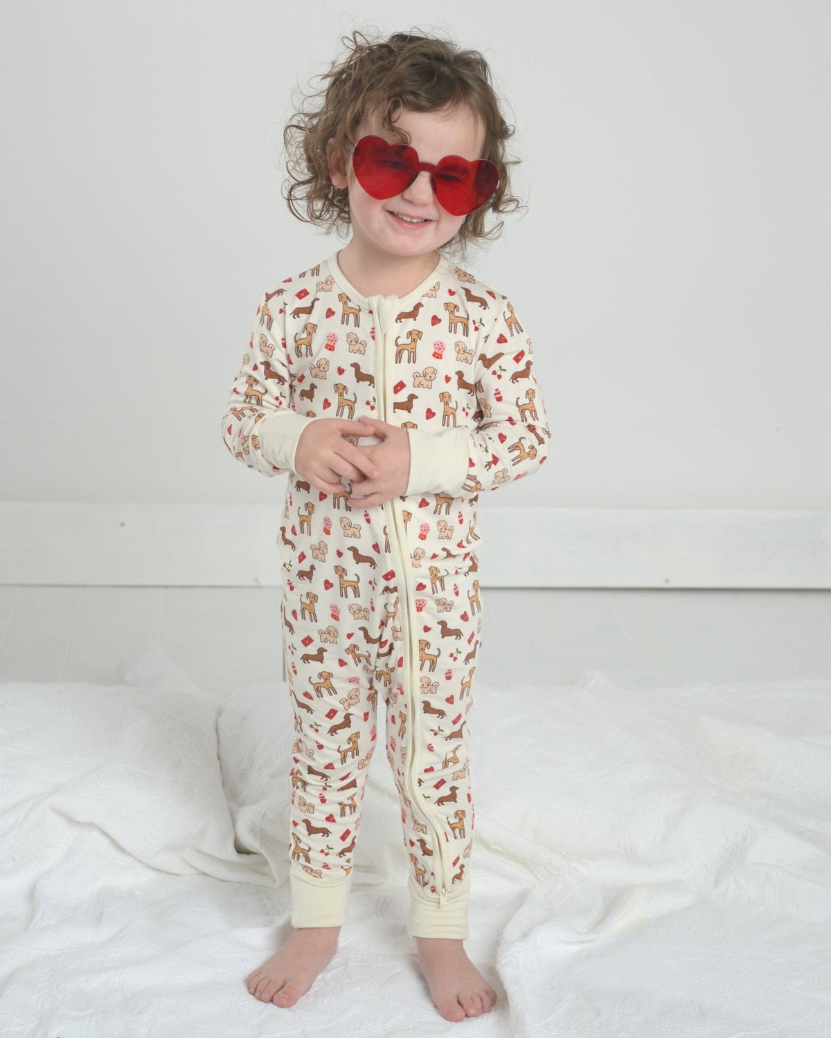 Toddler dog-print bamboo pajama romper with front zipper and long sleeves, cream base