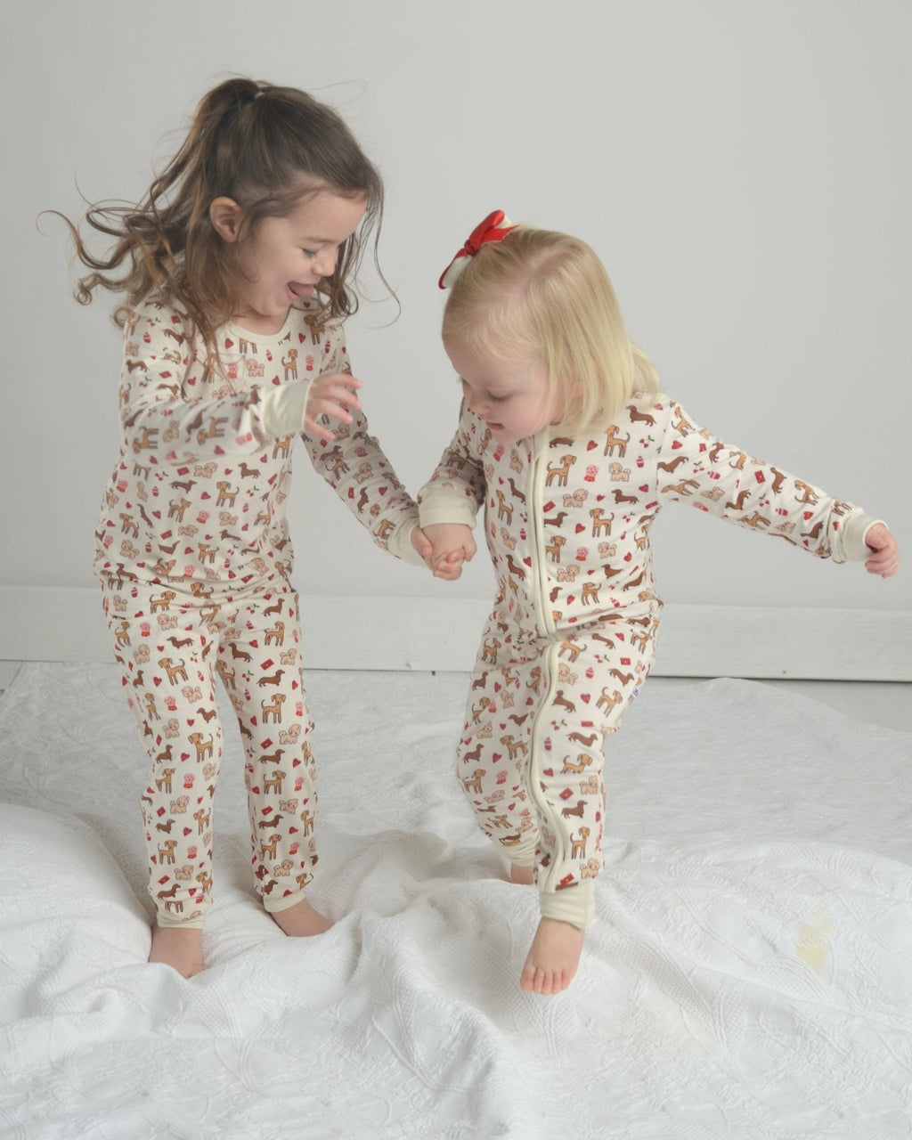 Toddler dog-print pajama romper with front zipper, long sleeves, and footed cuffs, cream